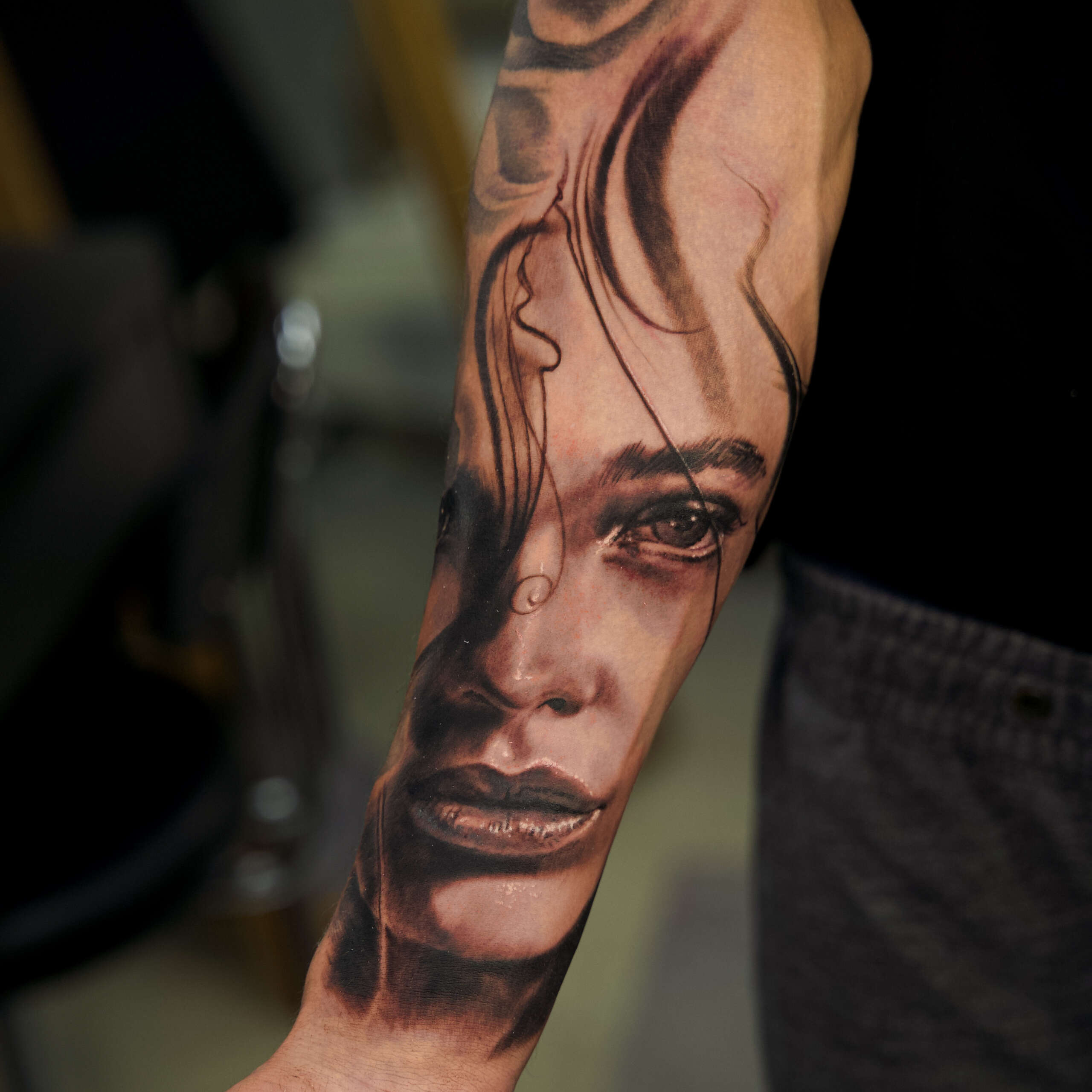 Ein Porträt Tattoo von einer Frau. Das Tattoo wurde auf den Unterarm eines Mannes gestochen